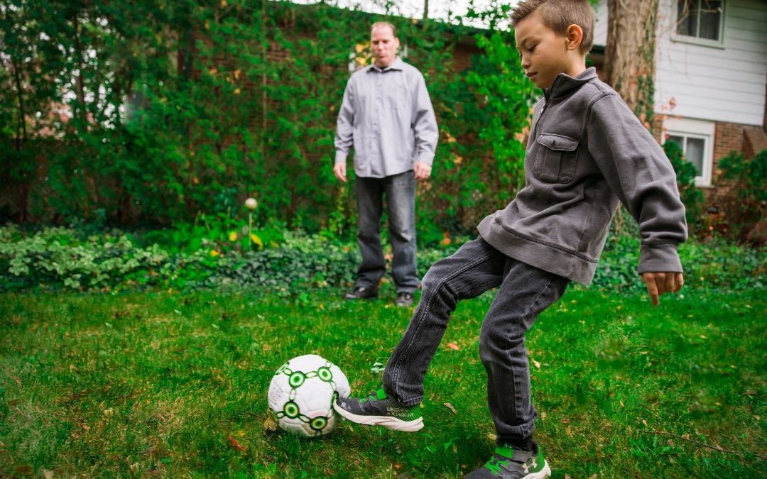 família jogando bola no jardim