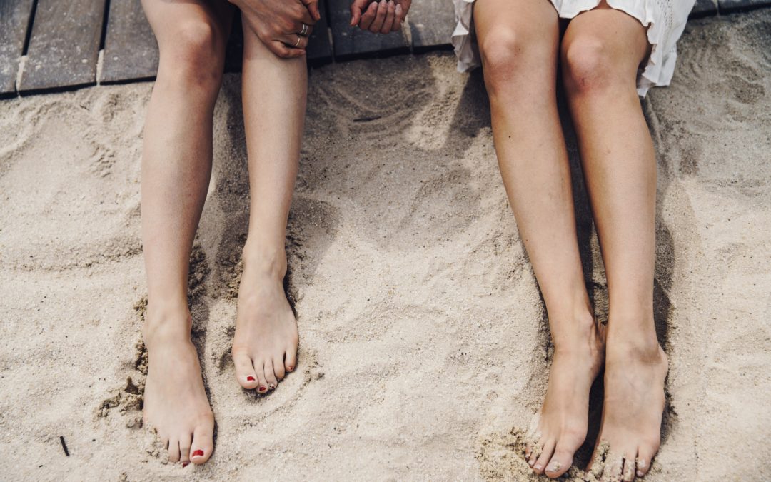 duas mulheres na praia usando técnicas para relaxar