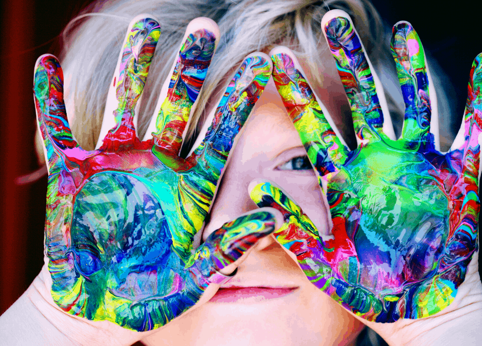 Criança com as mãos sujas de tinta colorida